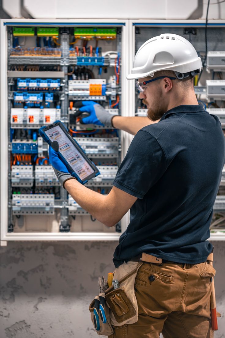 Electrician servicing energized panel with PPE